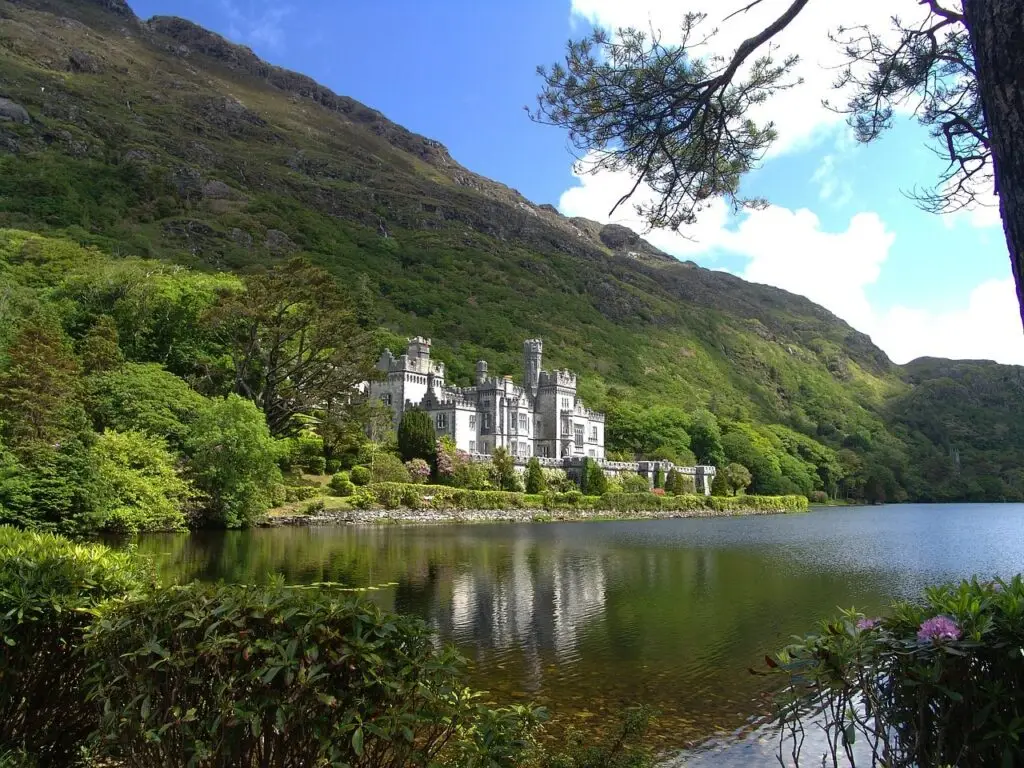 Kylemore Abbey Ireland historic castle reflected in lake surrounded by lush green mountains, popular tourist attraction featured on Ireland Prestige Tours
