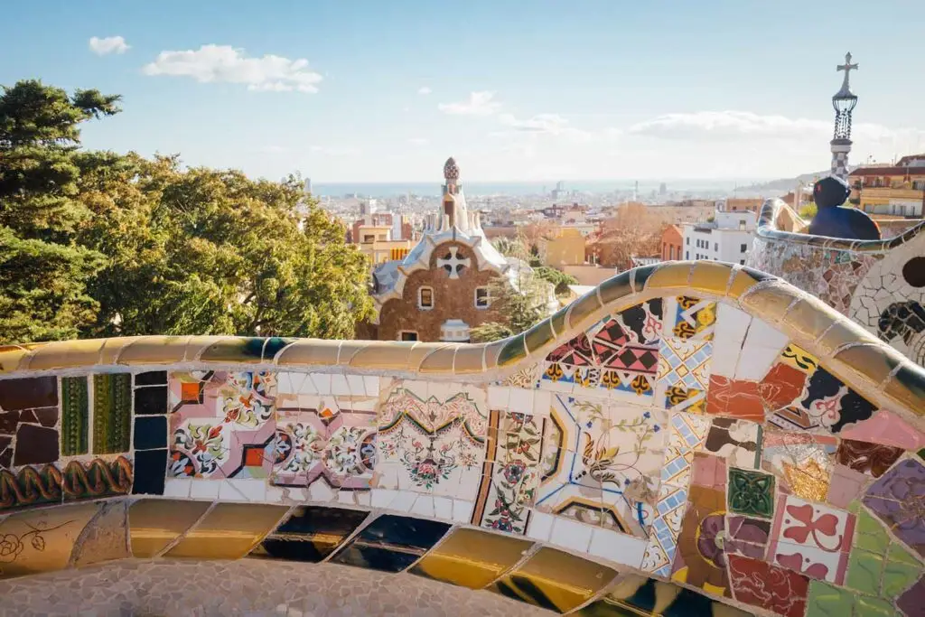 Colorful mosaic bench and scenic city view at Parc Güell in Barcelona, Spain, a famous Gaudí landmark and popular tourist attraction
