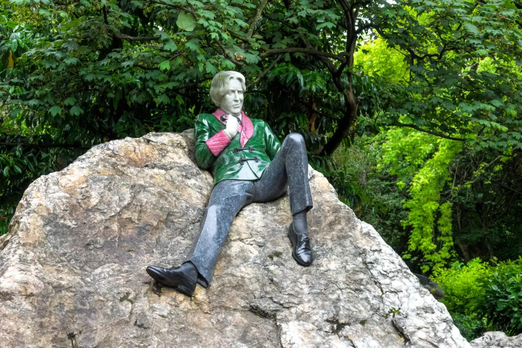 Colorful statue on a large rock surrounded by greenery in Merrion Square Park, Dublin, Ireland, a popular tourist attraction and cultural landmark