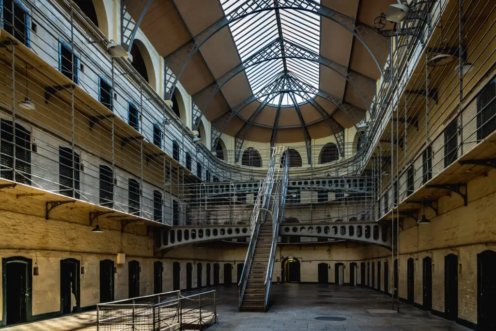 Interior of Kilmainham Gaol in Dublin, Ireland, showcasing the historic prison’s architecture with iron staircases, walkways, and arched windows, a popular heritage attraction on Ireland tours