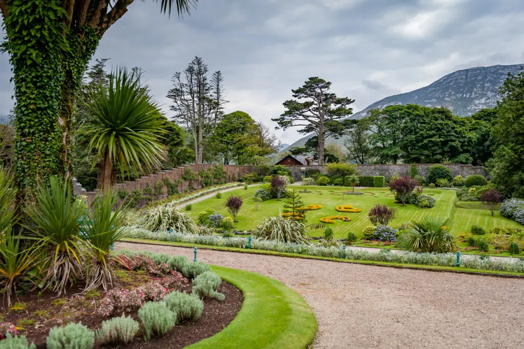 Beautiful landscaped Victorian walled garden at Kylemore Abbey, Connemara, Ireland surrounded by lush greenery and mountain views, a popular tourist attraction on Ireland tours