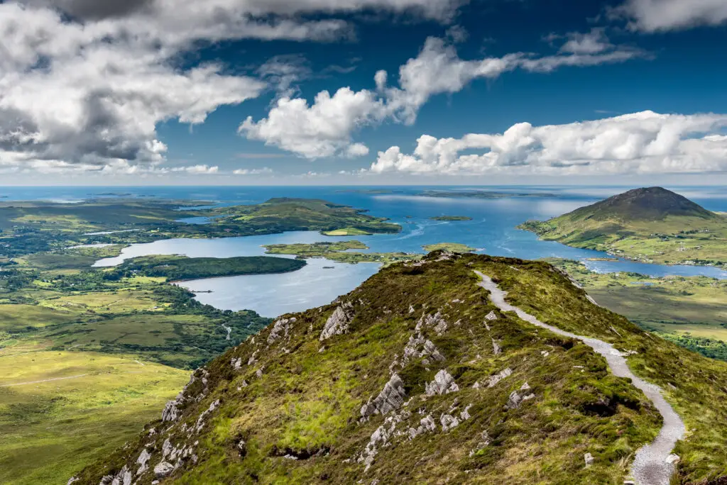 Scenic view from Diamond Hill in Connemara National Park, Ireland, showcasing rugged mountains, coastal landscape, and lush green countryside under a dramatic sky