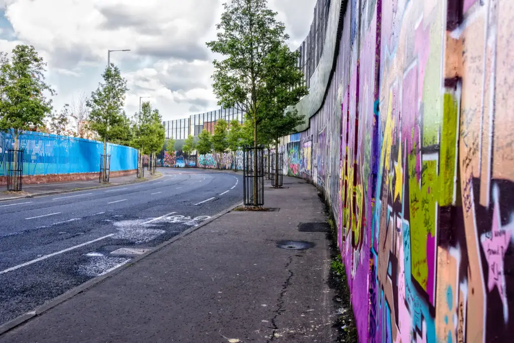 Colorful graffiti and murals on the Peace Wall in Belfast, Northern Ireland, a popular historical and cultural tourist attraction.