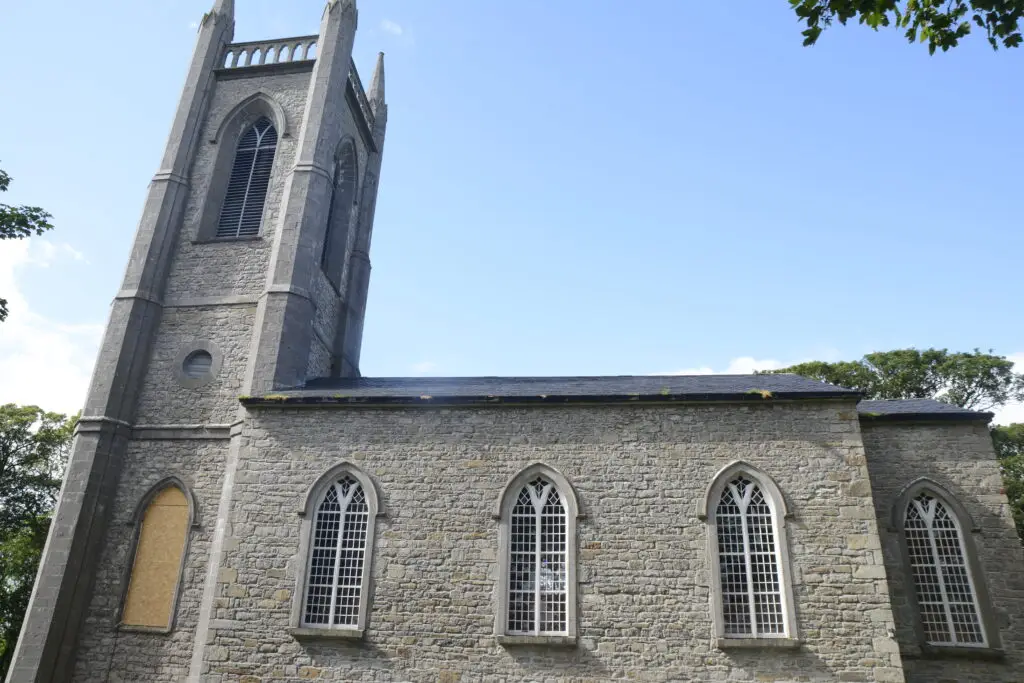Historic stone church with tall tower and arched windows in Drumcliff, Ireland, a popular heritage and sightseeing attraction on Ireland tours
