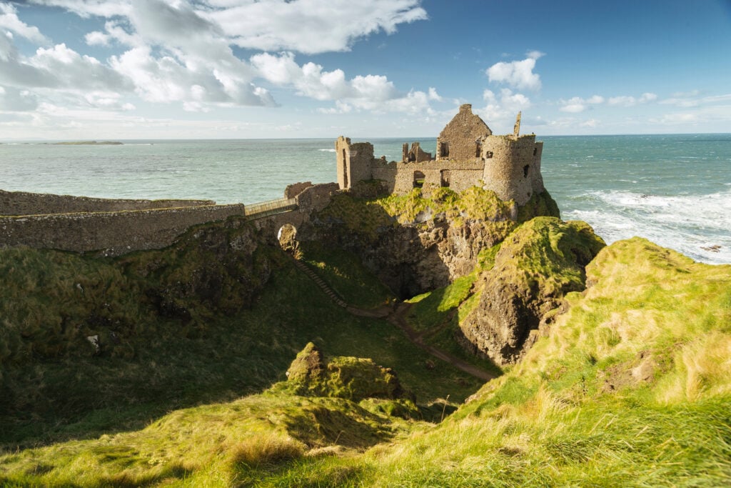 Historic Dunluce Castle on the Antrim coast, Northern Ireland, perched on dramatic cliffs overlooking the Atlantic Ocean, a popular sightseeing destination for Ireland tours
