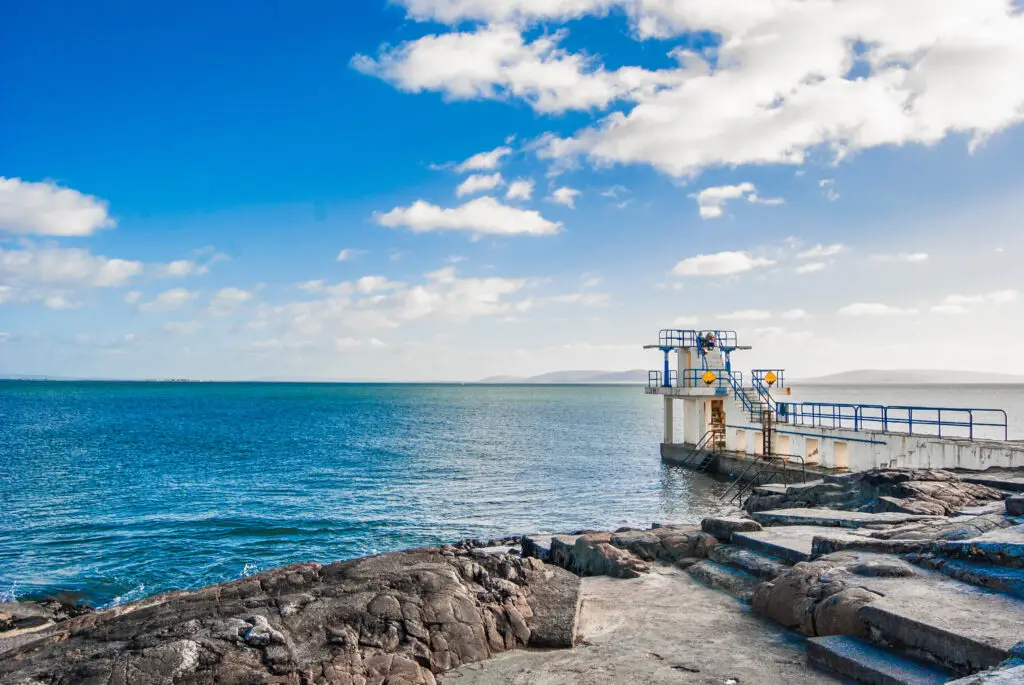 Scenic view of Salthill Promenade diving platform and Atlantic Ocean in Galway, Ireland on a sunny day, popular tourist attraction for coastal walks and sea swimming