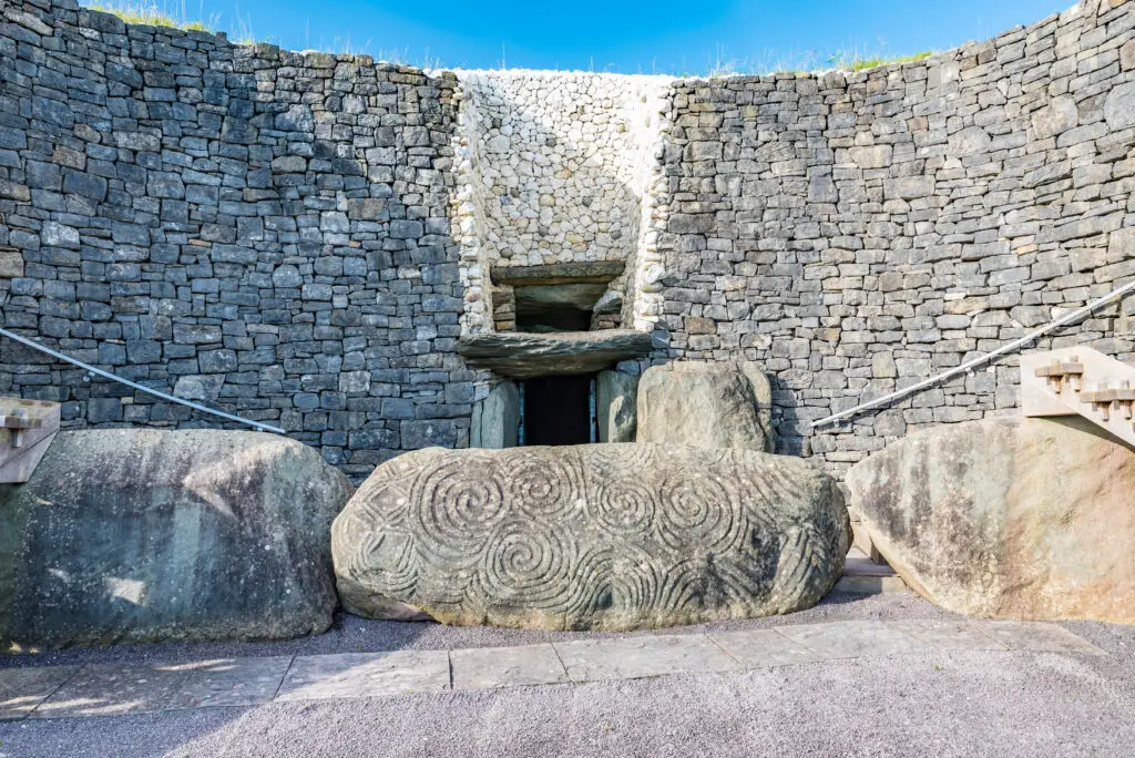 Entrance of Newgrange prehistoric passage tomb with spiral stone carvings in County Meath, Ireland