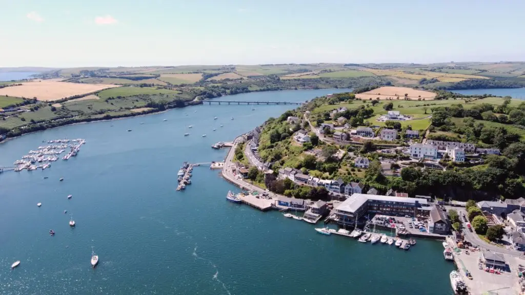 Aerial view of Kinsale Harbour in County Cork, Ireland showcasing boats, waterfront buildings, and scenic countryside, a popular tourist destination on Ireland’s Wild Atlantic Way.